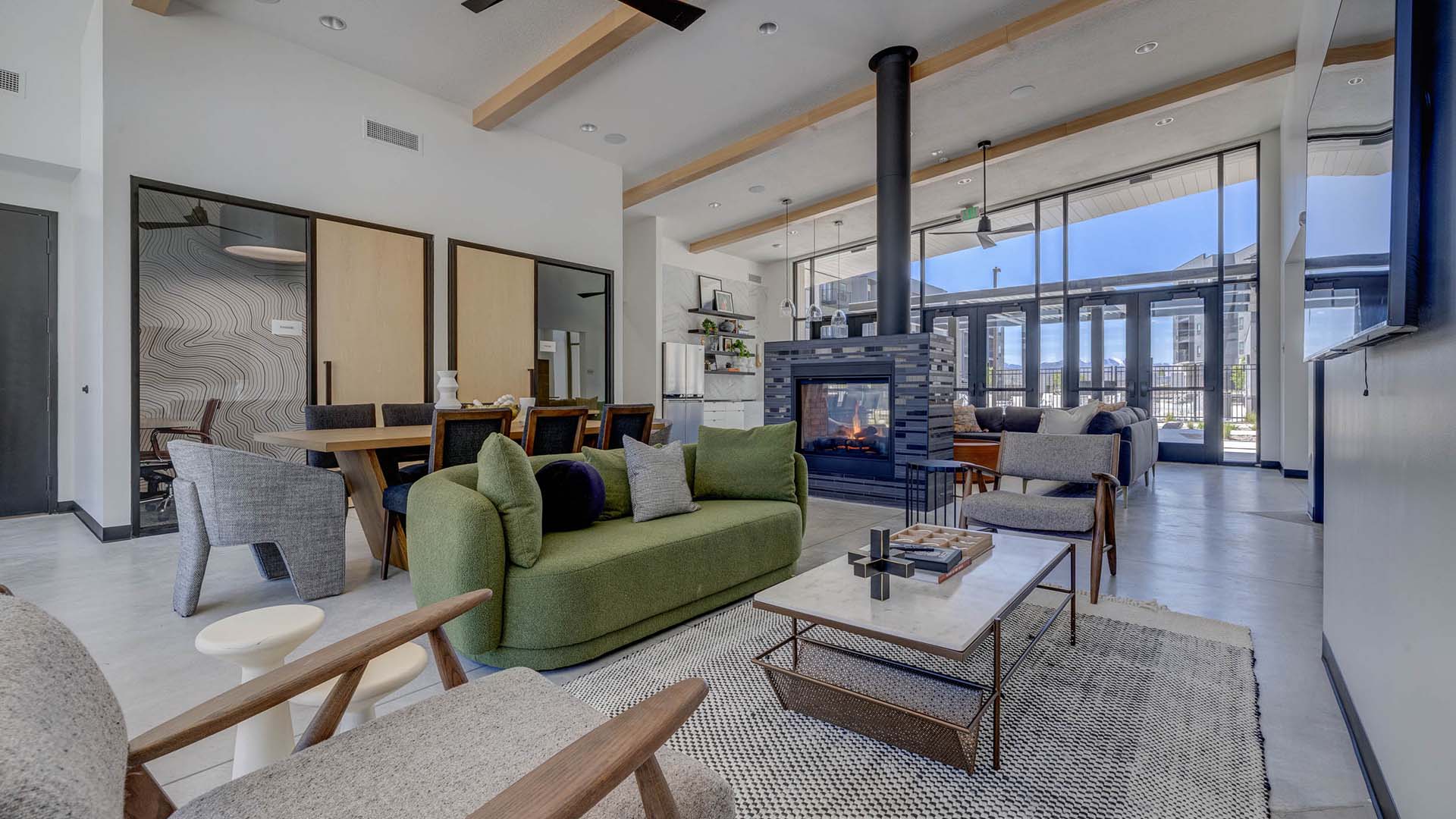 Terra Vista apartments lounge with plush seating, dining table, and fireplace.