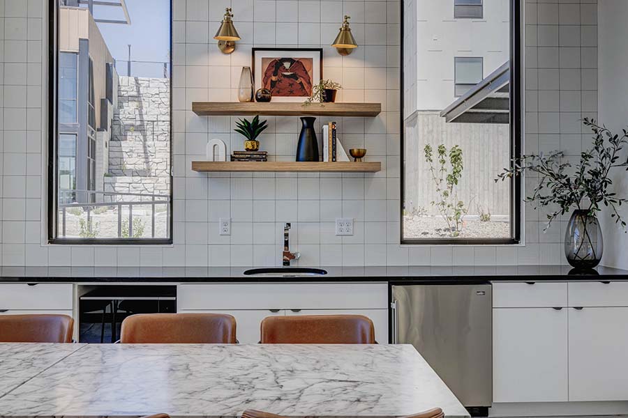Terra Vista apartments community kitchen with dining table, shelves with decor, and large windows.